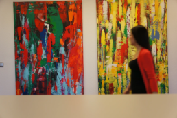 Frau läuft an gemietetem Gemälde im Büro vorbei